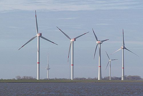 Photographie montrant une batterie de quatre éoliennes dans le port de Cuxhaven en Allemagne