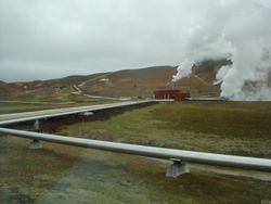 Phtographie montrant une source géothermique et les tuyaux de captage de la vapeur d'eau. Islande
