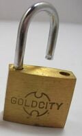 Un cadenas dont le boîtier est en laiton et l'anneau en acier inoxydable