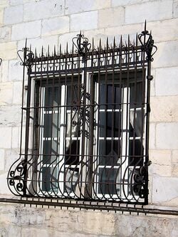 Fenêtre à carreaux, équipée d'une grille de protection
