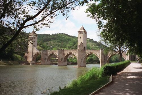 Le pont Valentré, édifié au XIVe&nbsp;siècle?, franchit le Lot (rivière), à l'ouest de la ville.