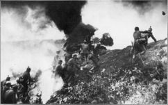 photographie d'époque montrant au milieu des impacts d'obus et de la fumée, un assaut de soldats allemands pendant la bataille de Verdun en mars 1916