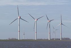 Photographie montrant une batterie de quatre éoliennes dans le port de Cuxhaven en Allemagne